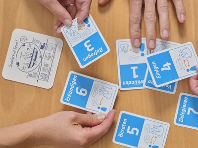 Mehrere Hände verschieben Karten zu Scrum-Themen