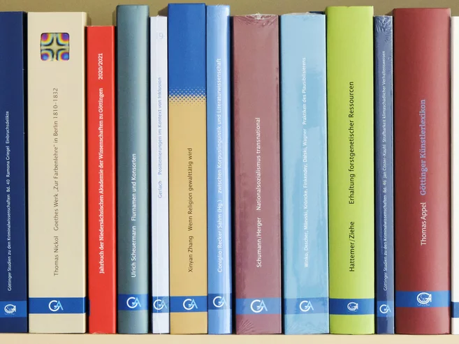 Dekorative Grafik mit mehreren Buchrücken des Universitätsverlages Göttingen